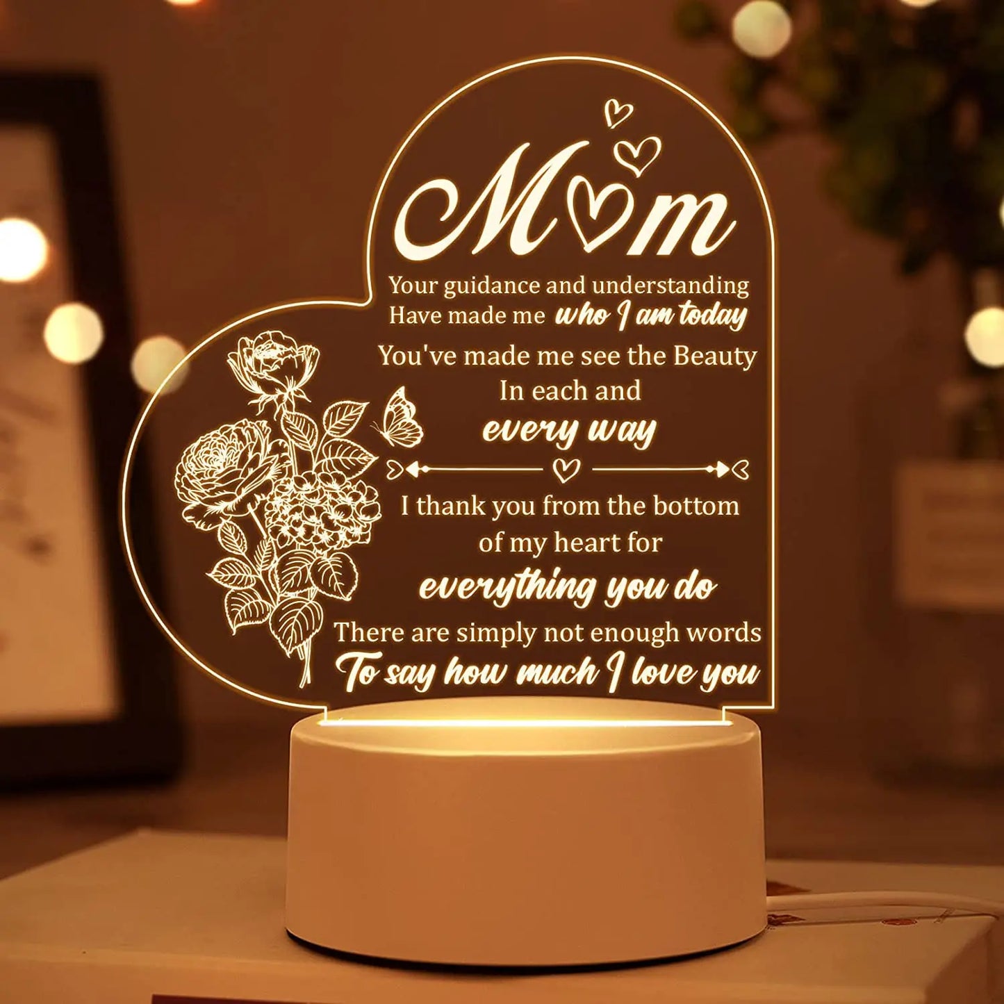 A close-up of an Engraved Acrylic Mom Night Light with LED bulbs, featuring a DIY shape and engraved with heartfelt sentiments. The night light is illuminated with a warm glow, perfect for bedroom decor.