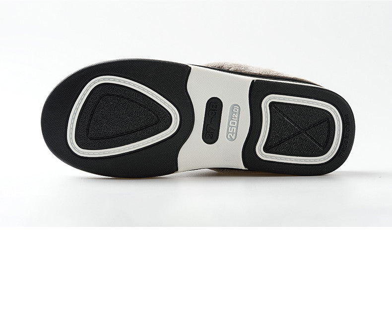 A pair of men's indoor slippers made of proportioned PU and plush insole material. The slippers are a light brown color and have a comfortable, relaxed design.