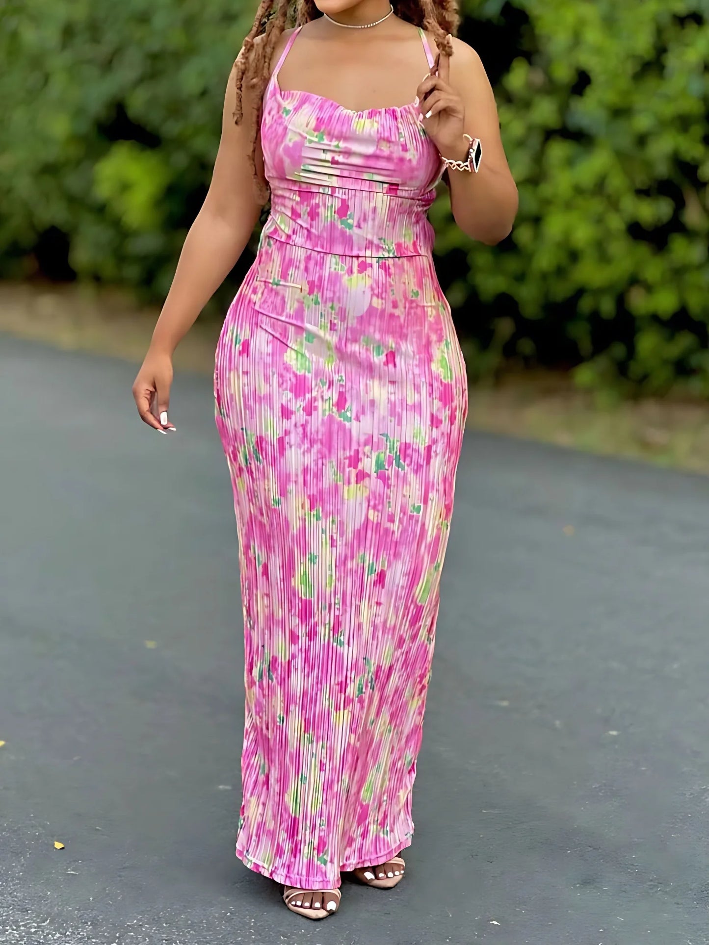 Woman wearing a colorful women's tie-dye spaghetti strap pleated bodycon dress with ankle-length slim fit – perfect for summer or beachwear.