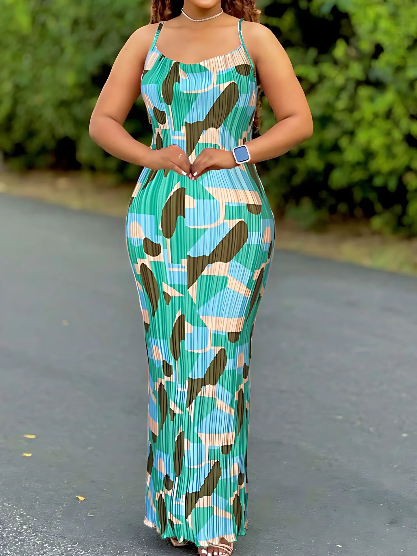 Woman wearing a colorful women's tie-dye spaghetti strap pleated bodycon dress with ankle-length slim fit – perfect for summer or beachwear.