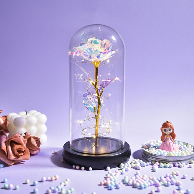 Artificial galaxy rose flowers in glass dome with LED lighting on black wood base, perfect for home decor or romantic gift for Valentine's Day, weddings. or any special occasion.