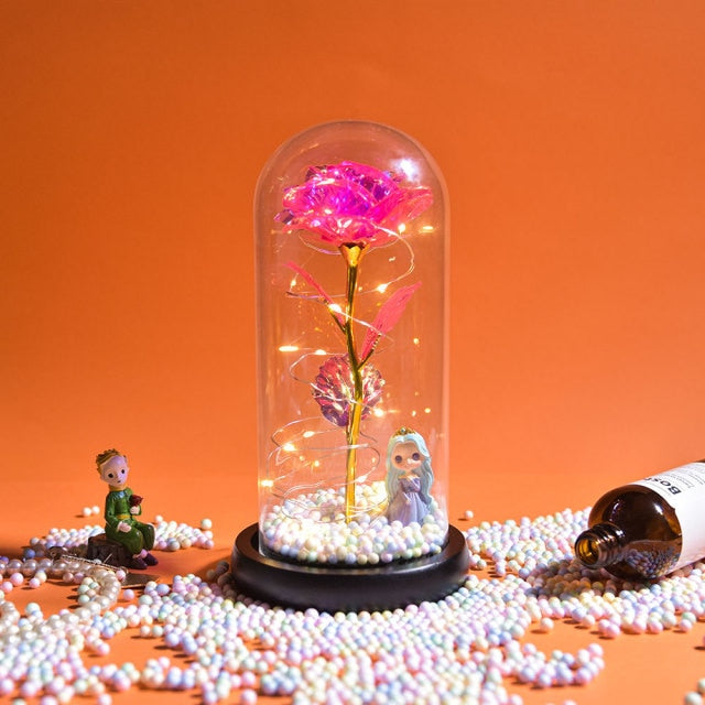 Artificial galaxy rose flowers in glass dome with LED lighting on black wood base, perfect for home decor or romantic gift for Valentine's Day, weddings. or any special occasion.