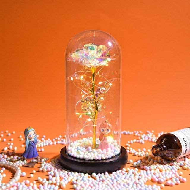 Artificial galaxy rose flowers in glass dome with LED lighting on black wood base, perfect for home decor or romantic gift for Valentine's Day, weddings. or any special occasion.