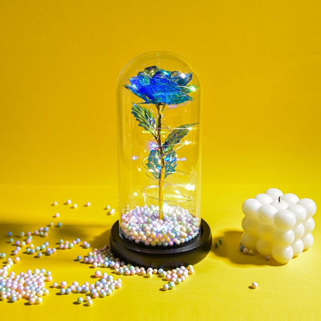 Artificial galaxy rose flowers in glass dome with LED lighting on black wood base, perfect for home decor or romantic gift for Valentine's Day, weddings. or any special occasion.