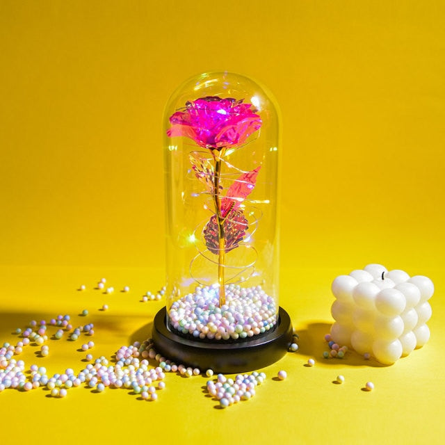 Artificial galaxy rose flowers in glass dome with LED lighting on black wood base, perfect for home decor or romantic gift for Valentine's Day, weddings. or any special occasion.