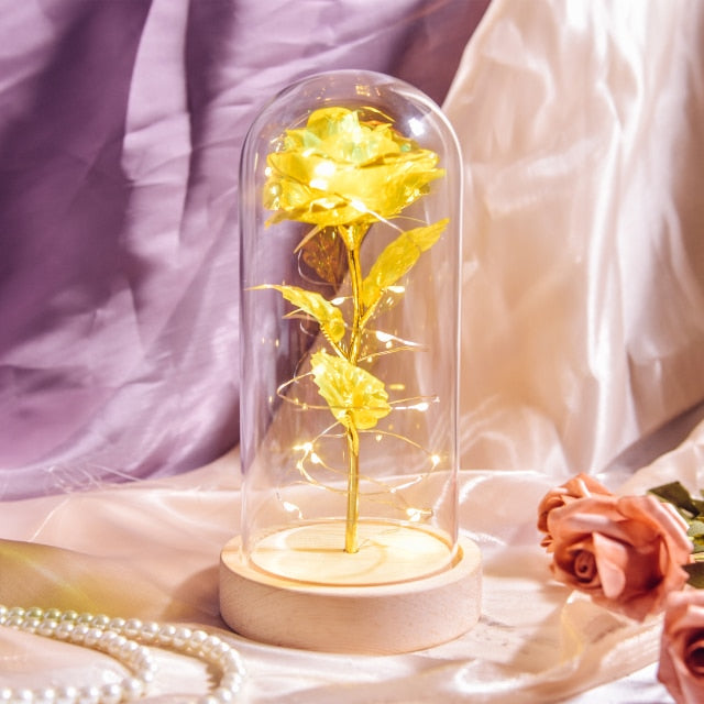 Artificial galaxy rose flowers in glass dome with LED lighting on black wood base, perfect for home decor or romantic gift for Valentine's Day, weddings. or any special occasion.
