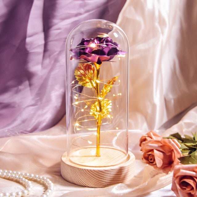 Artificial galaxy rose flowers in glass dome with LED lighting on black wood base, perfect for home decor or romantic gift for Valentine's Day, weddings. or any special occasion.