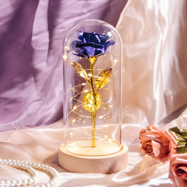 Artificial galaxy rose flowers in glass dome with LED lighting on black wood base, perfect for home decor or romantic gift for Valentine's Day, weddings. or any special occasion.