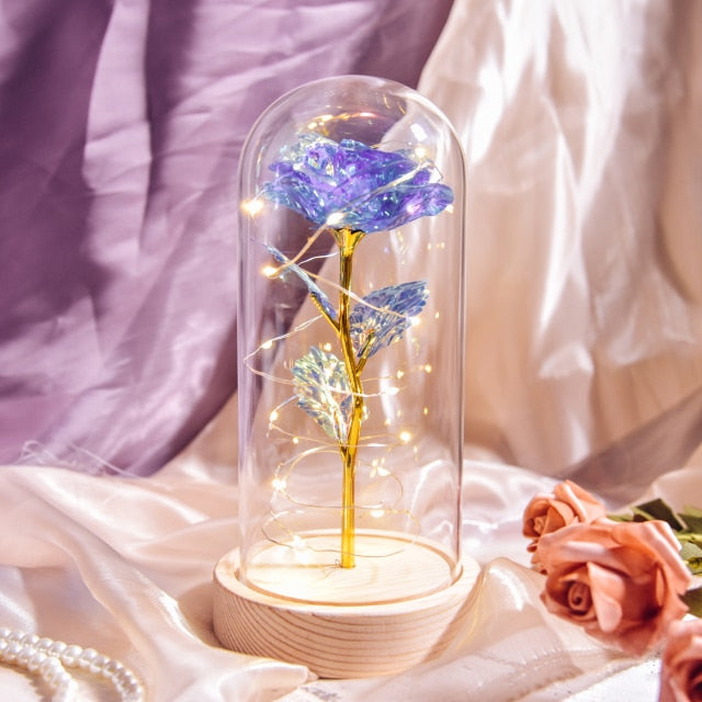 Artificial galaxy rose flowers in glass dome with LED lighting on black wood base, perfect for home decor or romantic gift for Valentine's Day, weddings. or any special occasion.
