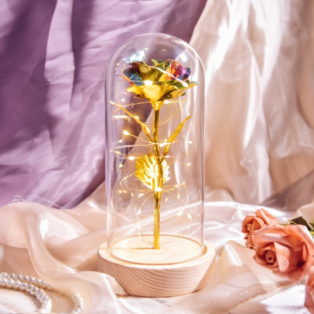 Artificial galaxy rose flowers in glass dome with LED lighting on black wood base, perfect for home decor or romantic gift for Valentine's Day, weddings. or any special occasion.
