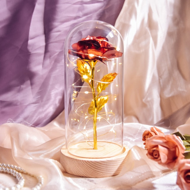 Artificial galaxy rose flowers in glass dome with LED lighting on black wood base, perfect for home decor or romantic gift for Valentine's Day, weddings. or any special occasion.